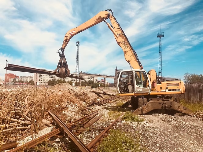 Pika noolega ekskavaator lammutab metallkonstruktsiooni