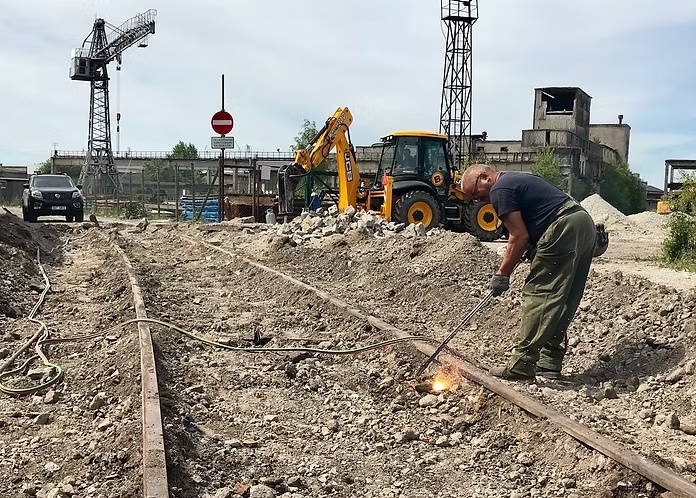Töötaja lõikab raudteerööpaid