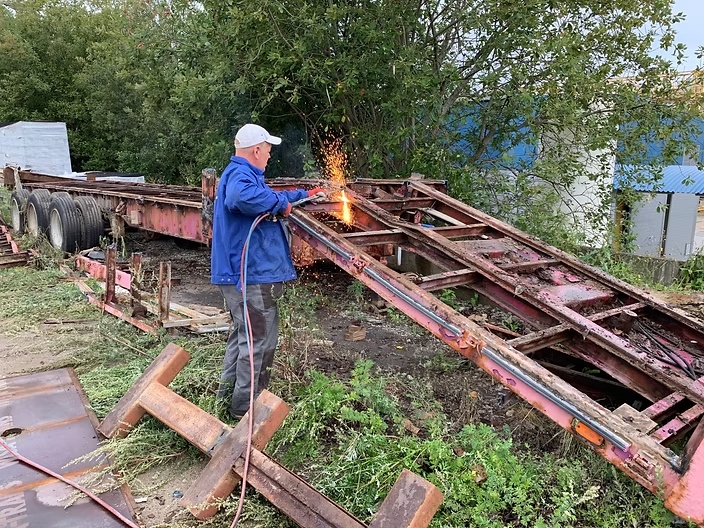 Töötaja lõikab metallkonstruktsiooni välitingimustes