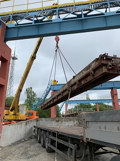 Kraana tõstab metallkonstruktsiooni veoki haagisele